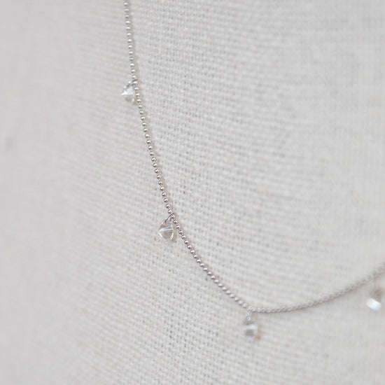 White gold diamond necklace on a fabric surface