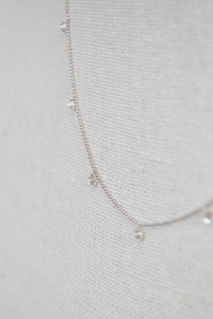 White gold diamond necklace on a fabric surface