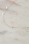 White gold diamond necklace on a marble surface