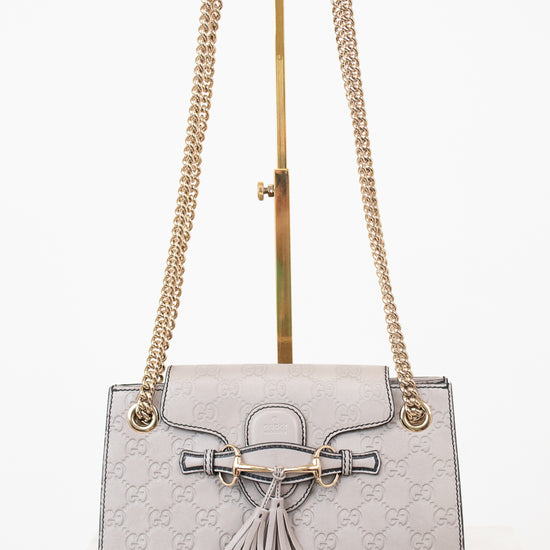 Gray handbag with gold chain strap on a white background