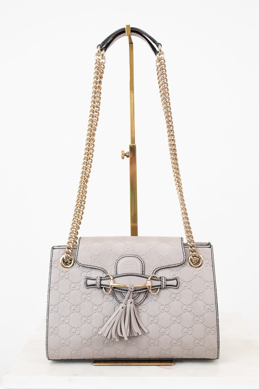 Gray handbag with gold chain strap on a white background