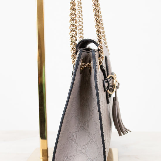 Grey handbag with chain strap on a white background