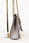 Grey handbag with chain strap on a white background