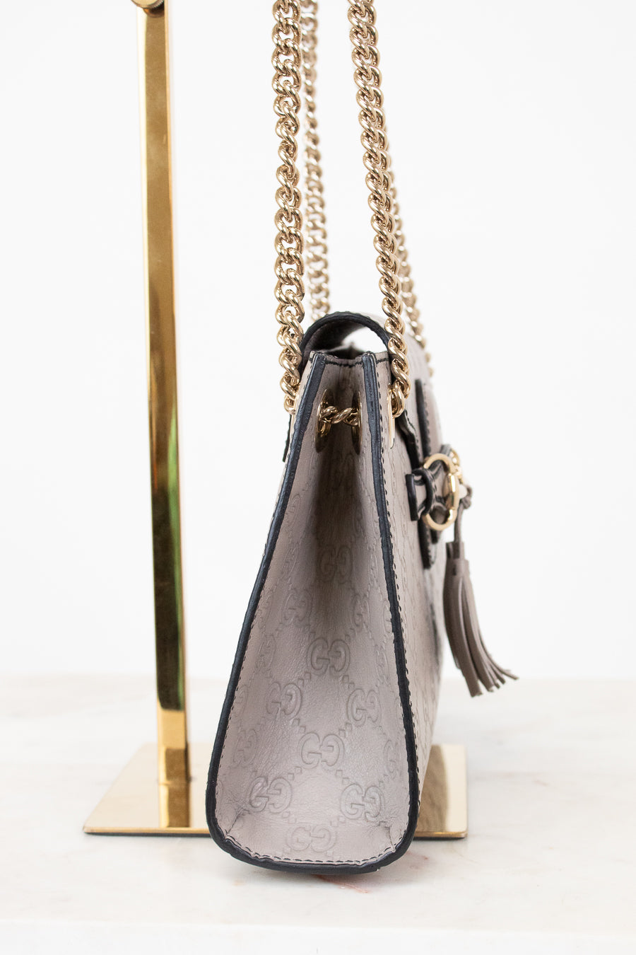 Grey handbag with chain strap on a white background