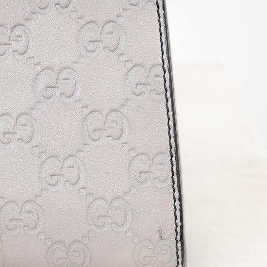 Close-up of a Gucci handbag with signature logo pattern on a white background