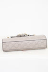 Light gray Gucci handbag with a decorative clasp on a white background