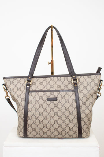 Beige and black handbag with a visible brand logo on a white background