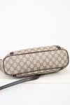 Beige patterned bag with brown strap on a white background