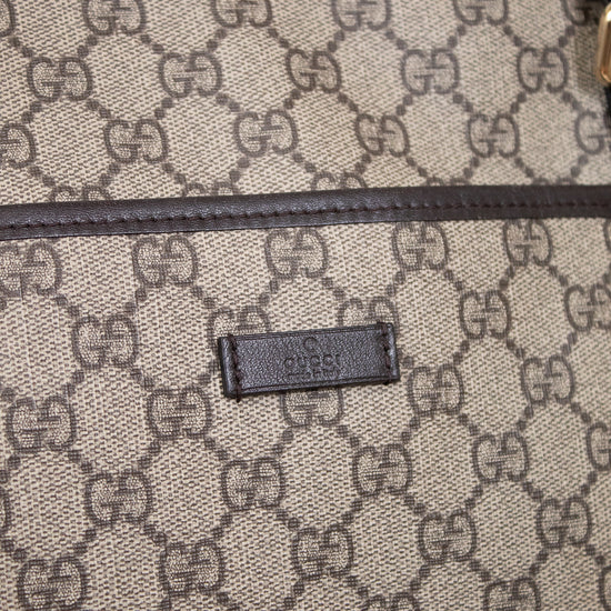Gucci bag with monogram pattern and visible logo on a light gray background