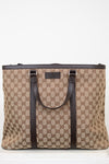Beige and brown patterned tote bag with black handles on a white background