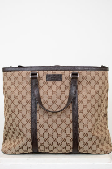 Beige and brown patterned tote bag with black handles on a white background