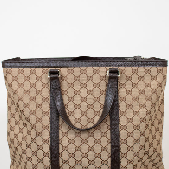 Beige and brown patterned tote bag with dark straps on a white background