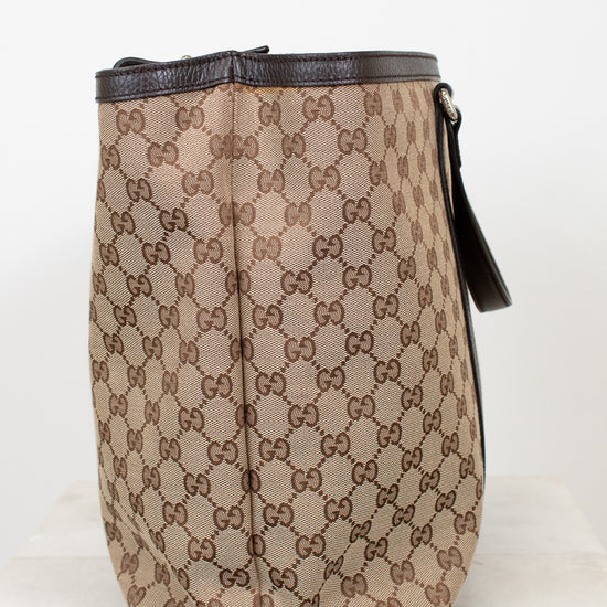 Beige and brown patterned bag with black accents on a white background