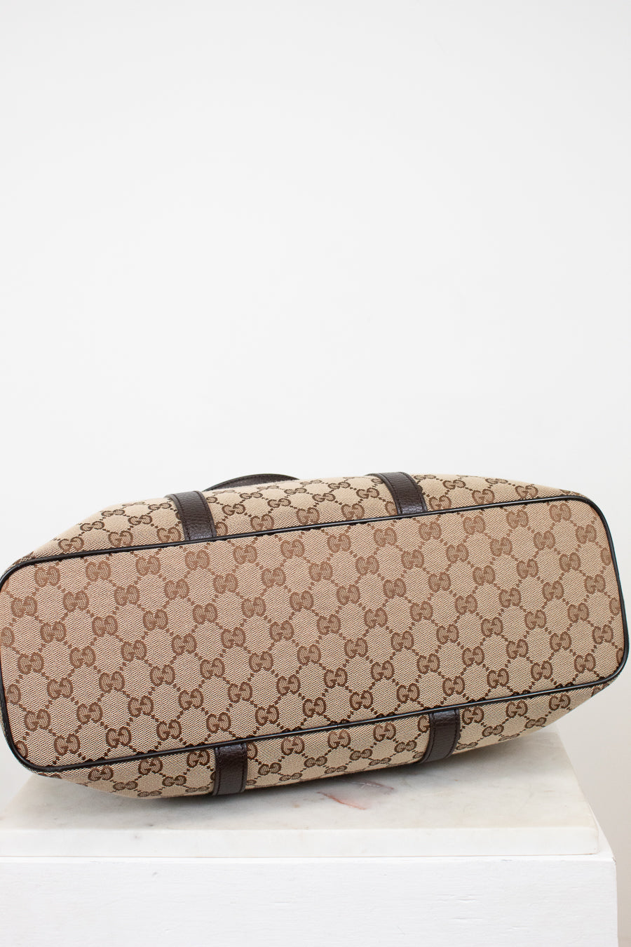 Beige and brown patterned suitcase on a white background