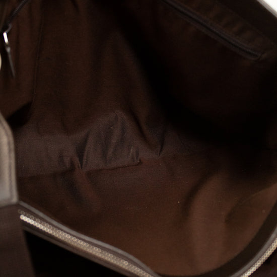 Close-up of a dark brown leather bag with a zipper.