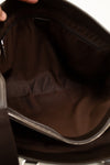 Close-up of a dark brown leather bag with a zipper.