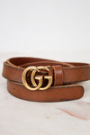 Brown leather belt with gold double G buckle on a light background