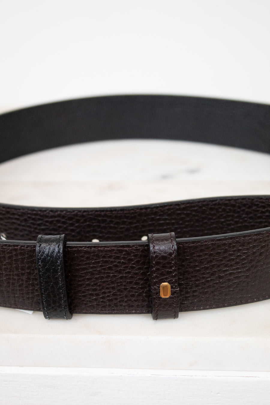 Black leather belt with a buckle on a white background
