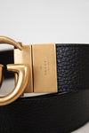 Close up of brand stamp on belt buckle on a light gray background