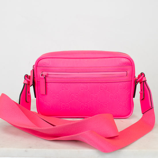 Pink crossbody bag with a strap on a white background