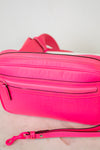 Hot pink crossbody with a strap on a white background