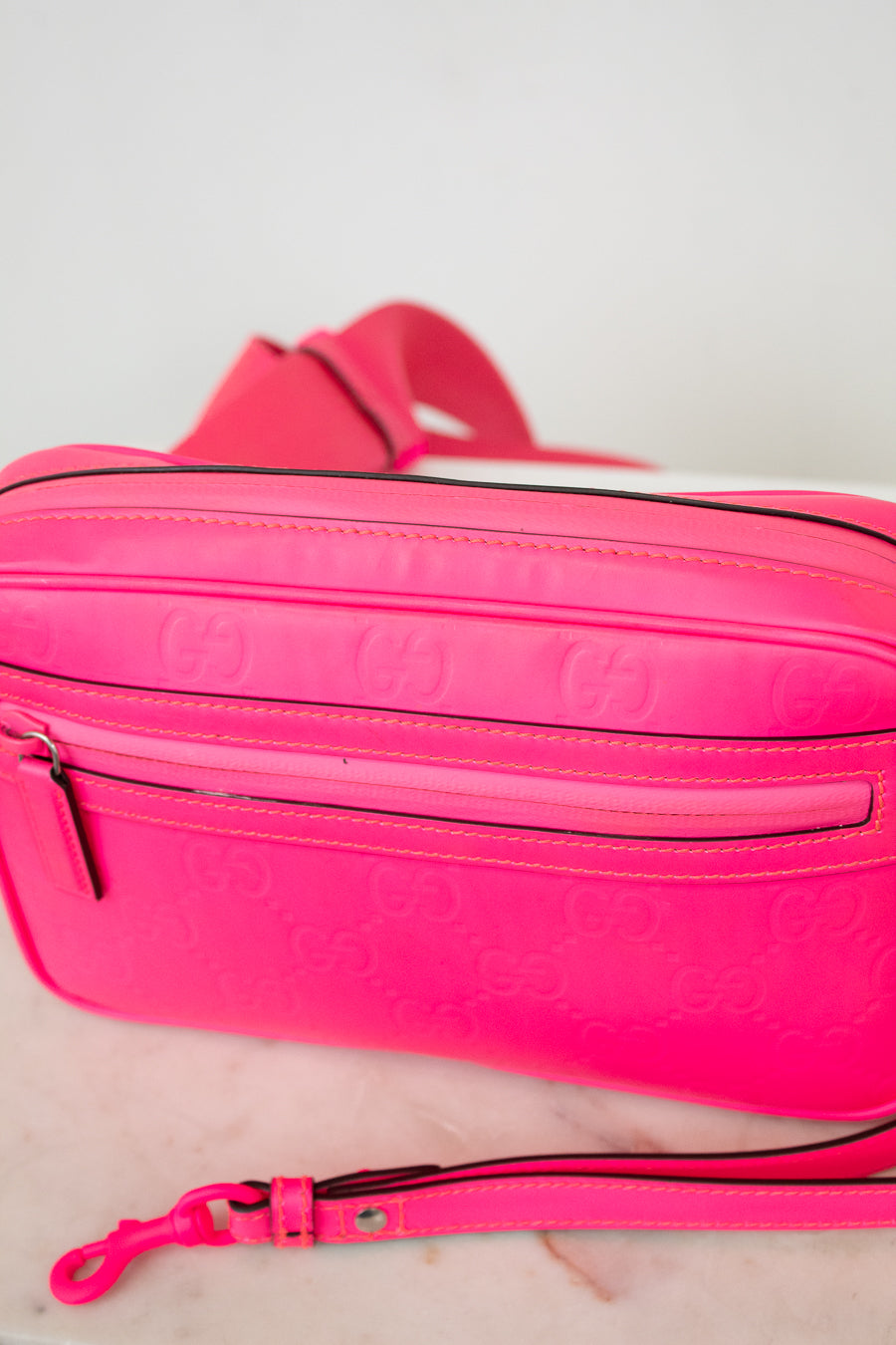 Hot pink crossbody with a strap on a white background