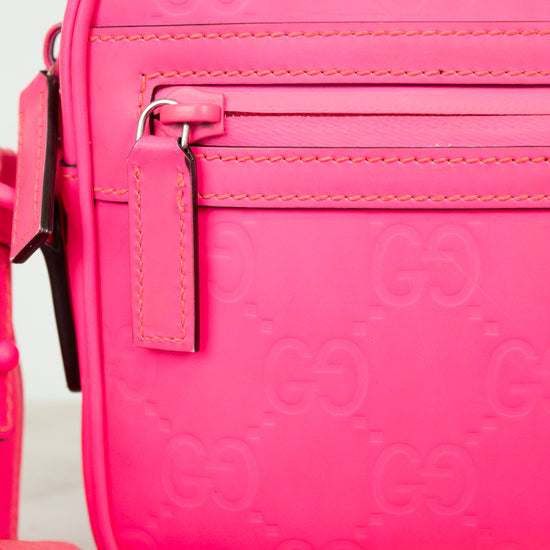 Pink crossbody bag with Gucci logo pattern on a white background