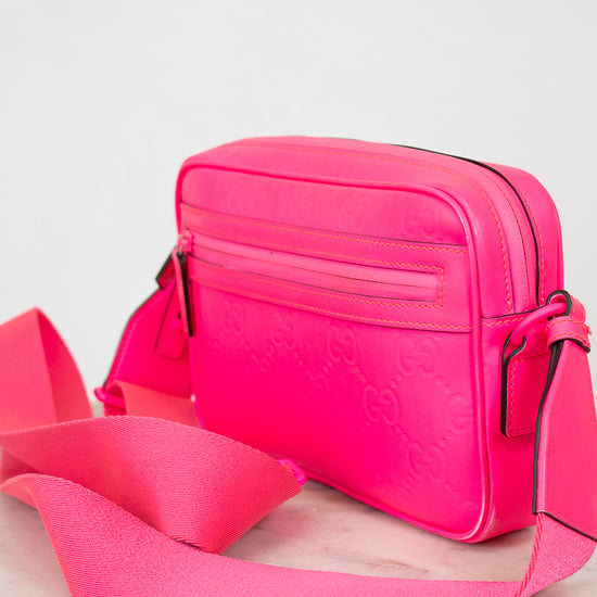 Pink handbag with a matching pink strap on a white background