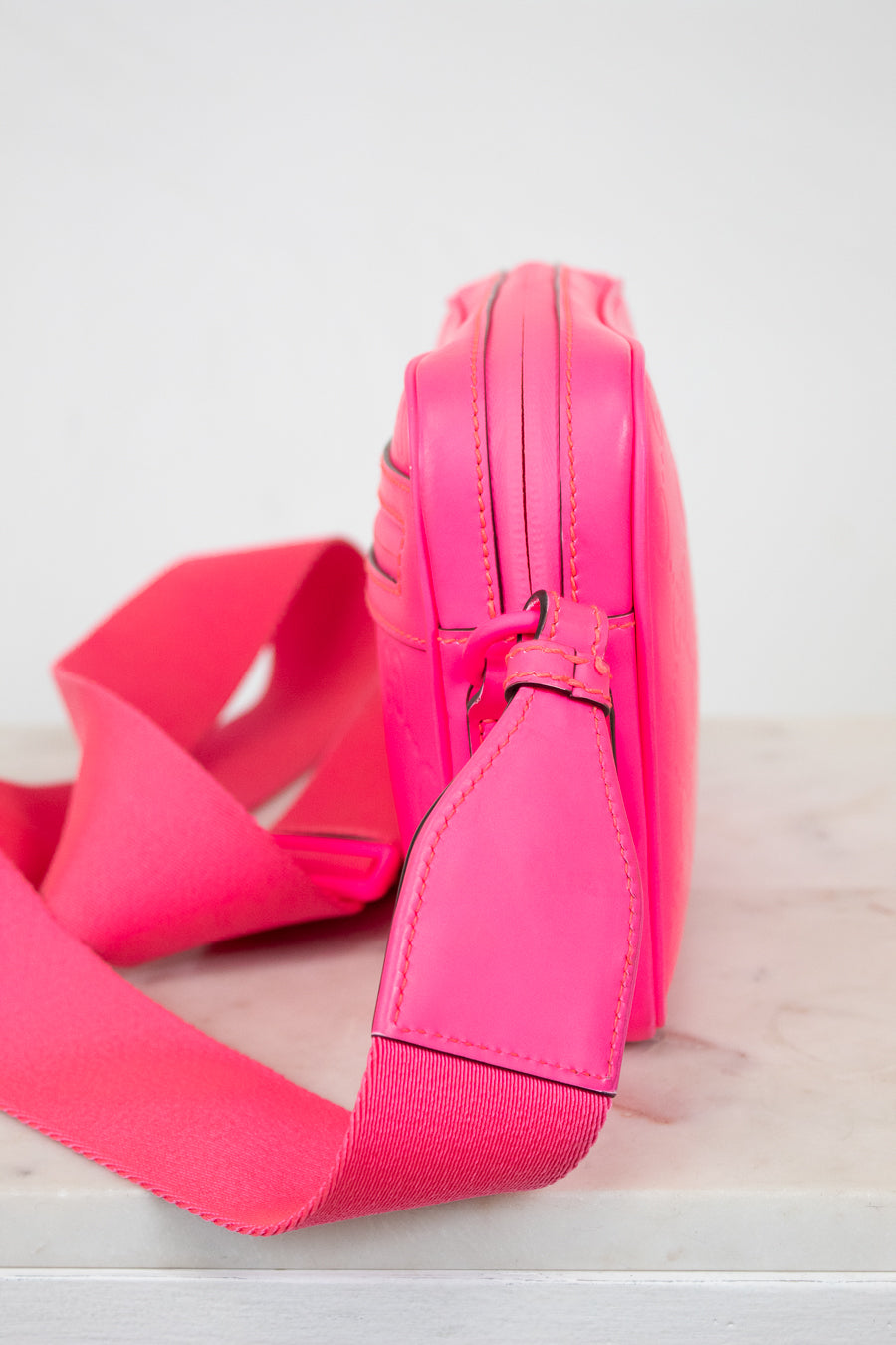 Pink bag side view with strap on a white background