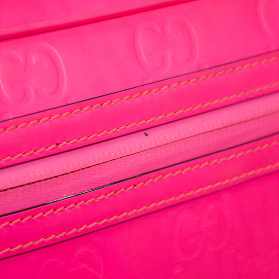 Close-up of a pink purse with stitching details on a white background