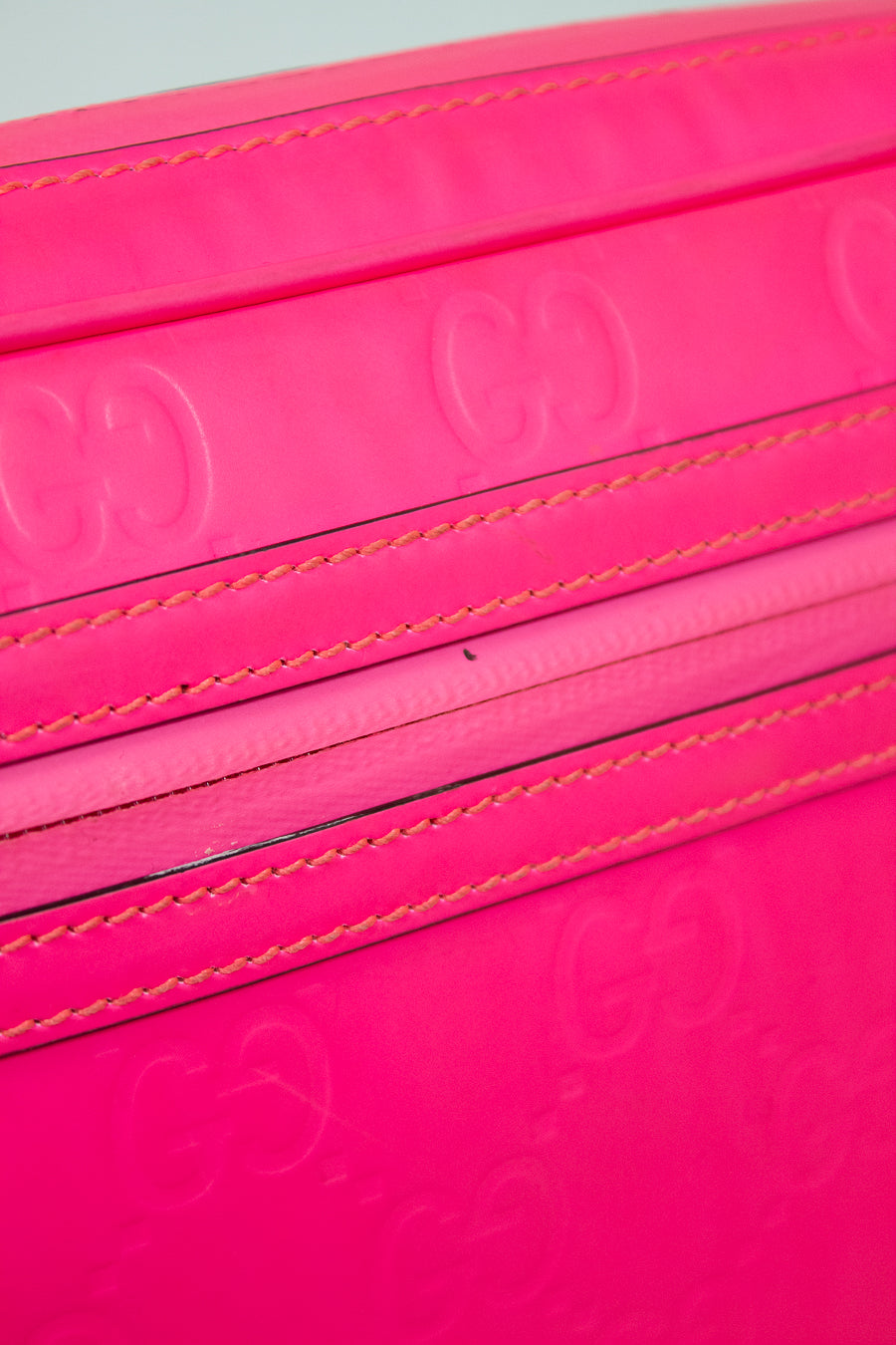 Close-up of a pink purse with stitching details on a white background