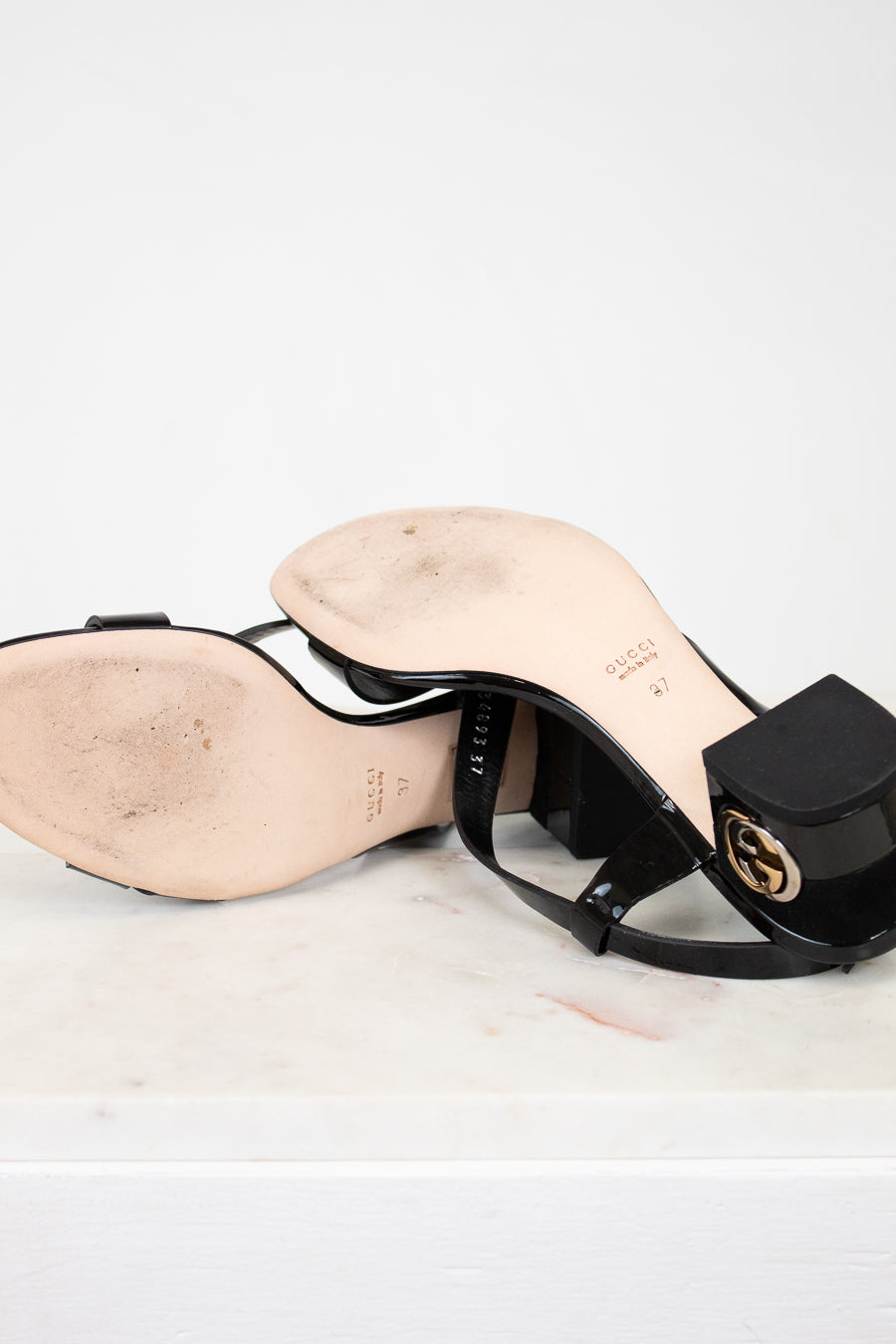 Black high-heeled sandal with a brand logo on a light background
