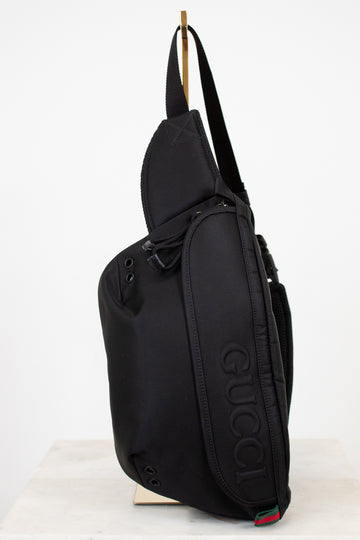 Black sling bag with Gucci logo on a white background