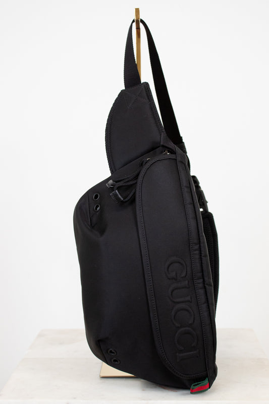 Black sling bag with Gucci logo on a white background