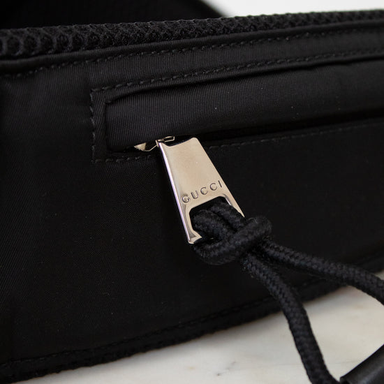 Black bag with Gucci logo on a marble surface