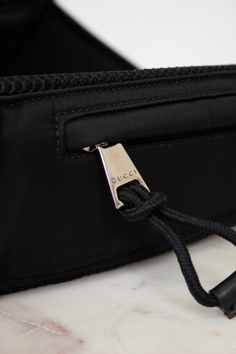 Black bag with Gucci logo on a marble surface