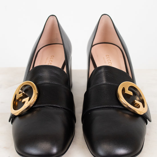 Front view of black leather loafers showing round toe and gold 'GG' logo hardware