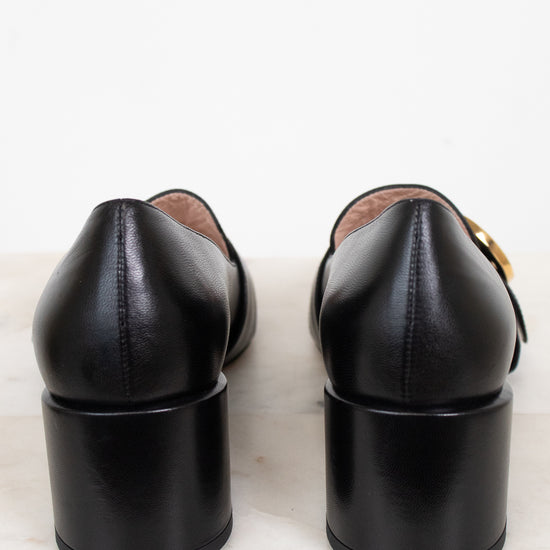 Heel view showing chunky heel of black leather loafers