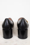 Heel view showing chunky heel of black leather loafers