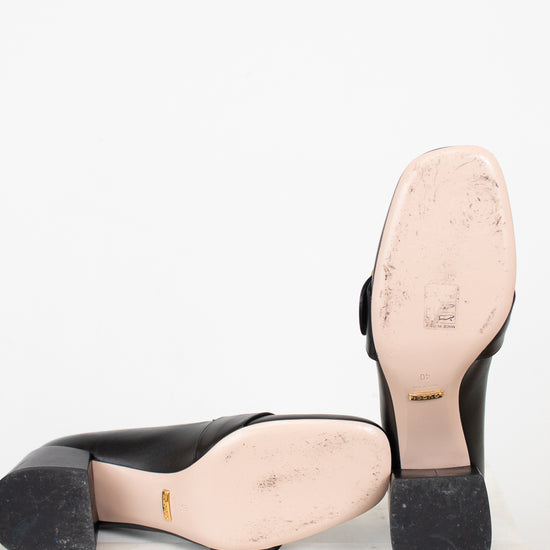 Bottom exterior sole view of chunky heeled shoes laying against a plain background