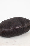 A dark brown Gucci monogram canvas and leather bag or pouch, photographed on a light marble surface against a white background.