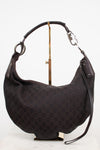 A dark brown Gucci hobo shoulder bag with the classic GG monogram canvas, displayed on a gold stand against a white background.