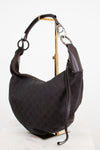 A dark brown Gucci hobo shoulder bag with the brand's signature GG monogram canvas, displayed on a gold stand against a white background.