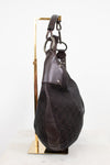 A dark brown Gucci hobo bag made of GG Supreme canvas and leather, displayed on a gold-colored metal stand against a white background.