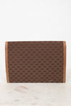 Brown Gucci monogram clutch purse with faint scratch on a white marble surface
