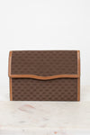 Brown Gucci monogram clutch purse on a white marble surface