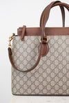 Gucci monogram canvas handbag with brown leather trim and handles, gold-tone hardware, and a detachable shoulder strap, shown on a clean white background.
