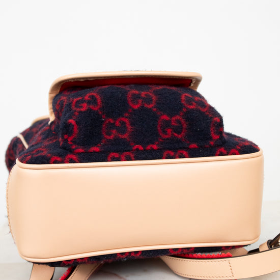 Designer handbag with red and black pattern on beige base