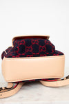 Designer handbag with red and black pattern on beige base