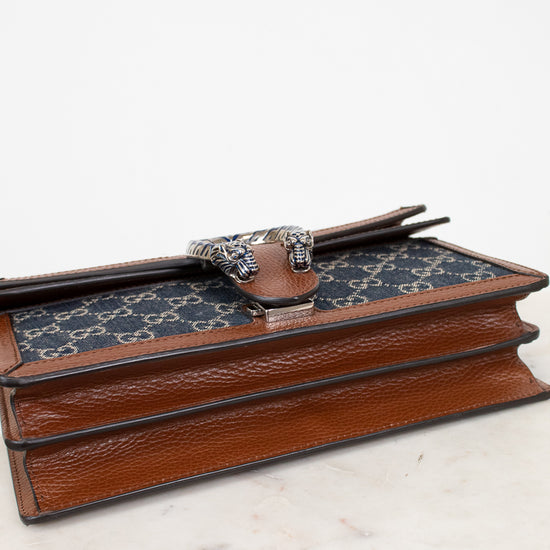 Gucci patterned handbag with brown leather details on a white surface